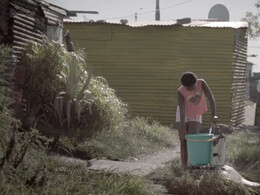 A girl gathering water in a South African township