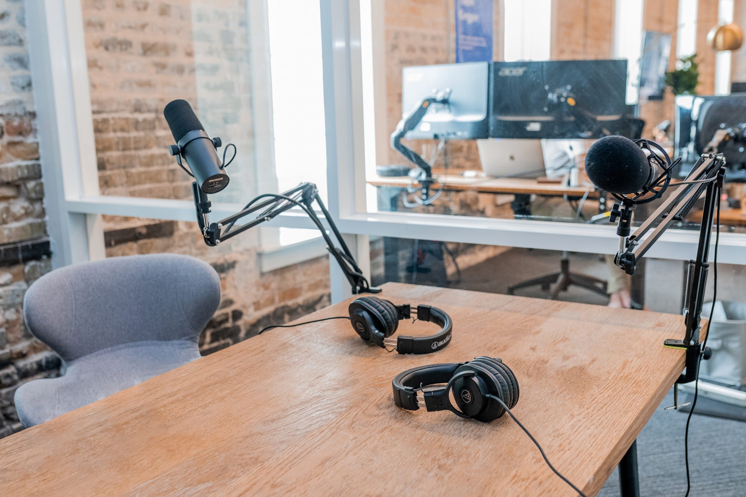 Two microphones and headphones in a podcast studio.