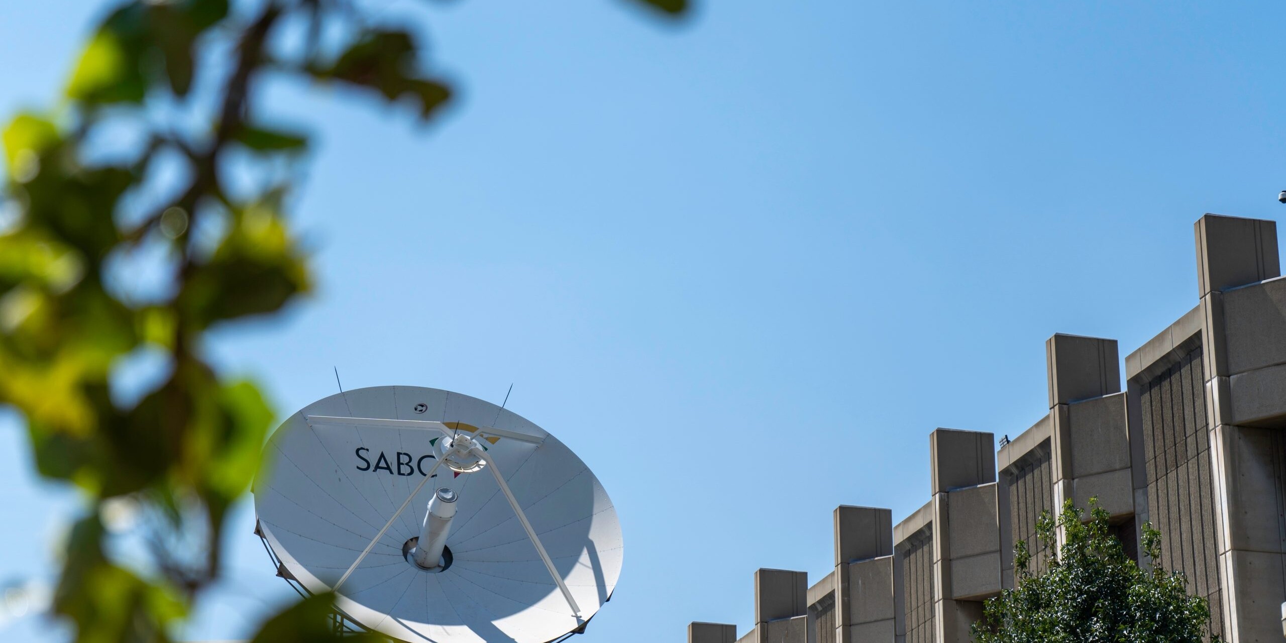 SABC-branded satellite against a blue sky.