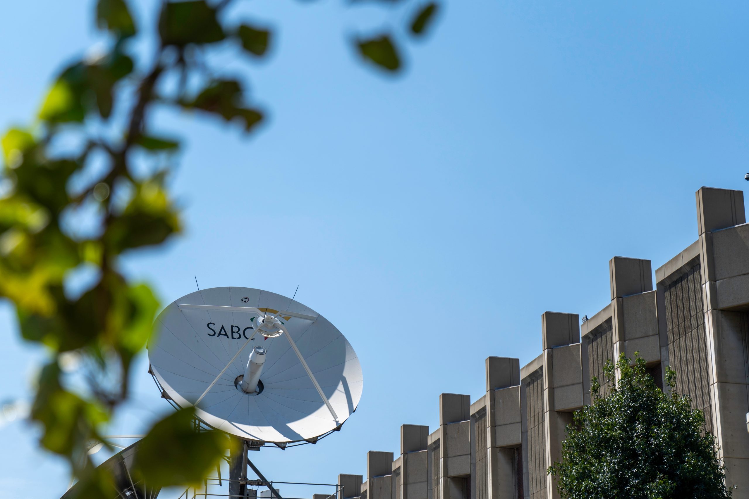 SABC-branded satellite against a blue sky.