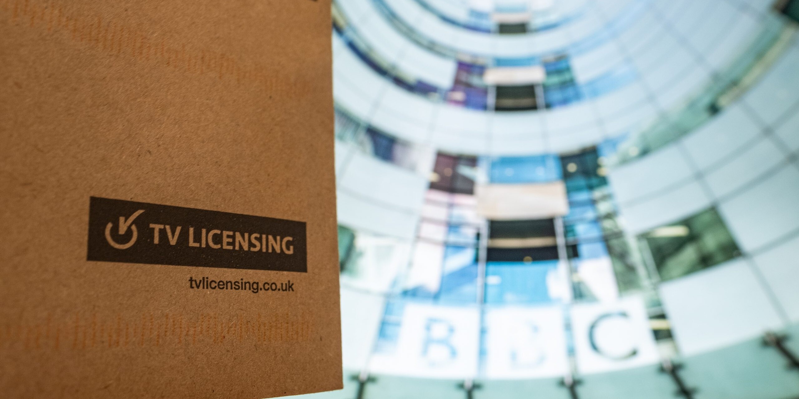 TV Licence envelope against an image of the BBC headquarters.