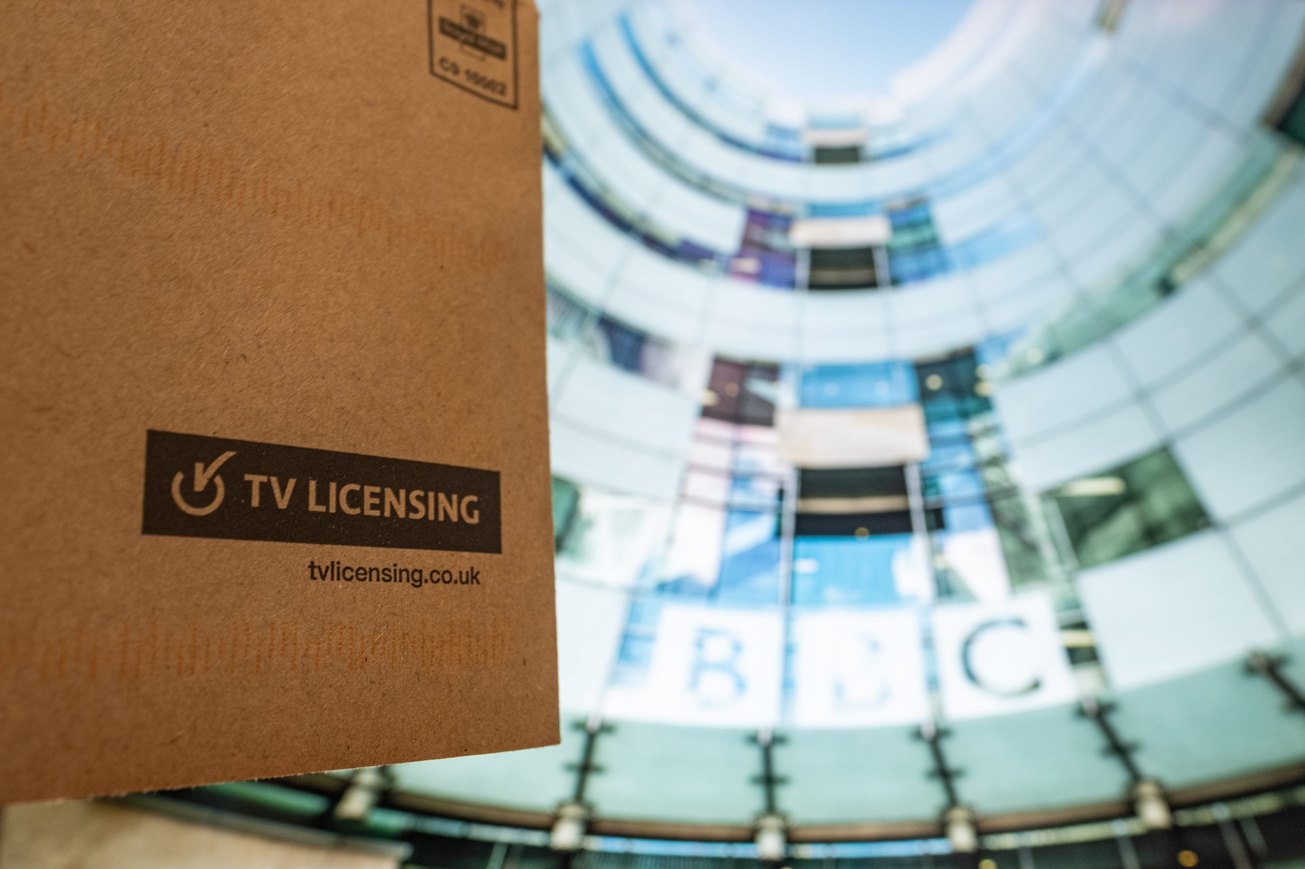 TV Licence envelope against an image of the BBC headquarters.