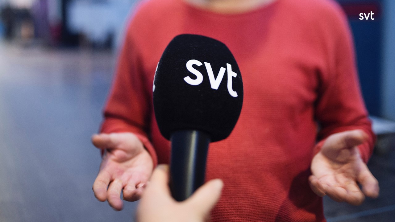 Hand holding a microphone with SVT branding.