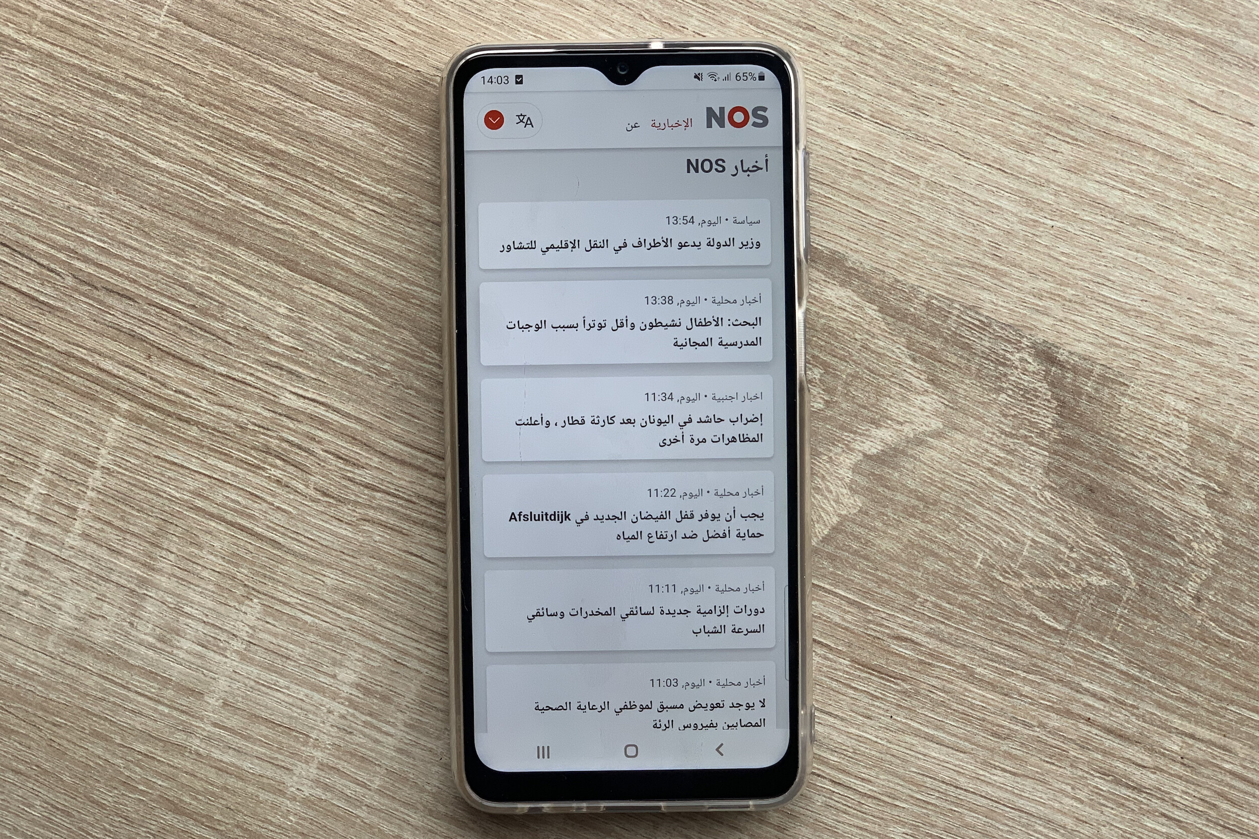 A mobile phone showing a translated article in Arabic.