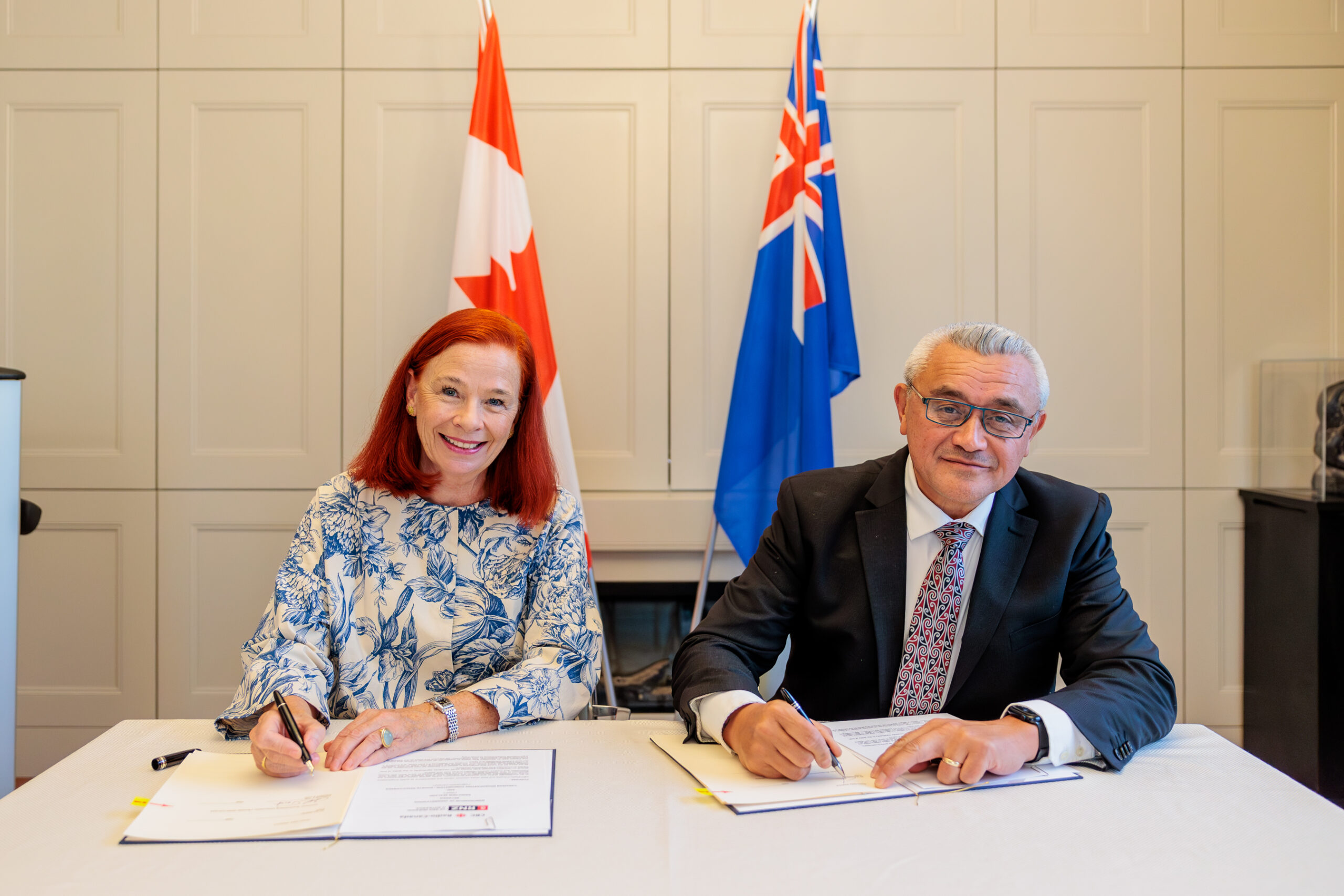 Catherine Tait and Jim Mather sat at a desk signing the MoU