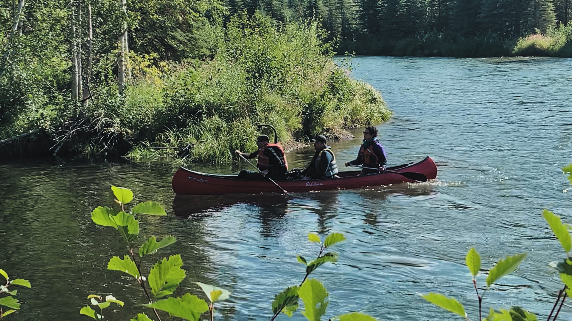 Three people on a canoe boat on a river
